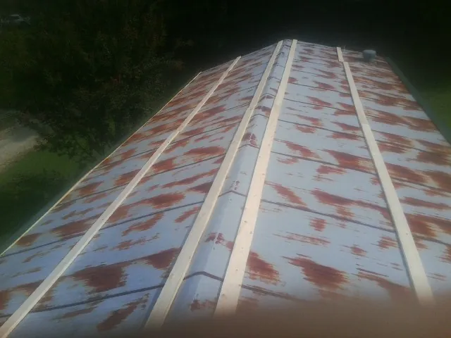 Rusted metal roof panels with new wood purlins before replacement — Storm Damage Roof Repair in Rawlins by Roofing Brothers