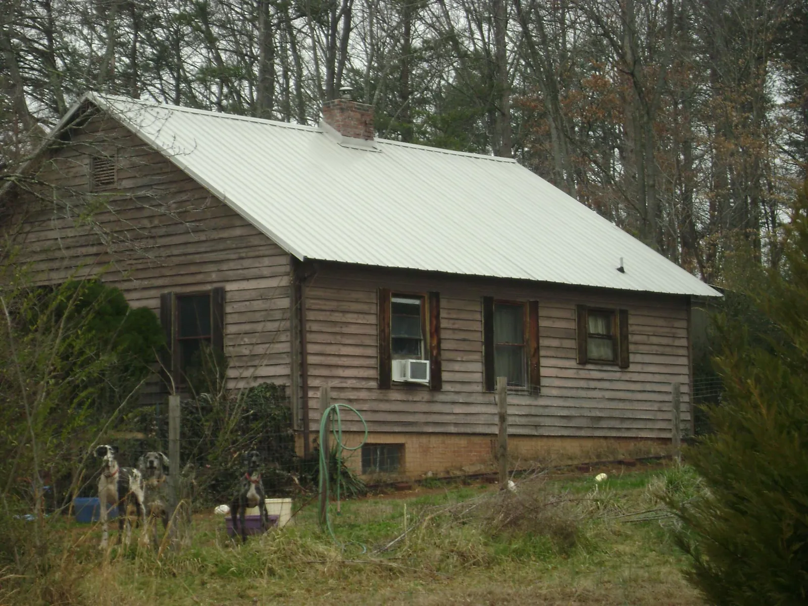 White metal roof on an old wood sided farmhouse, from a Metal Roof Installation job in Rawlins